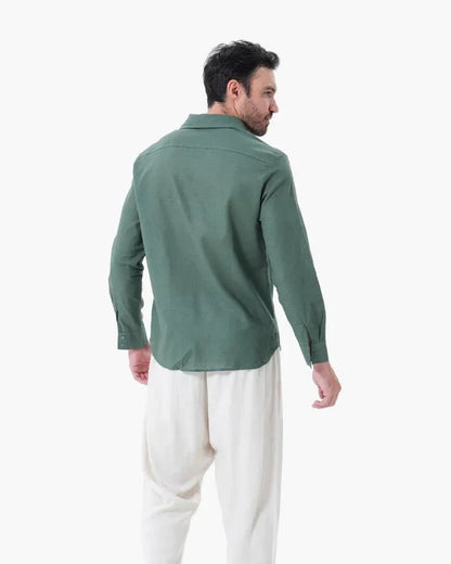 Man wearing green linen shirt and white linen pants, back view on white background