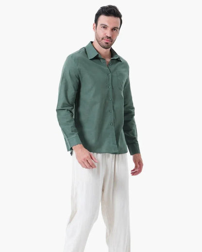 Man modeling green linen shirt and white linen pants on white background