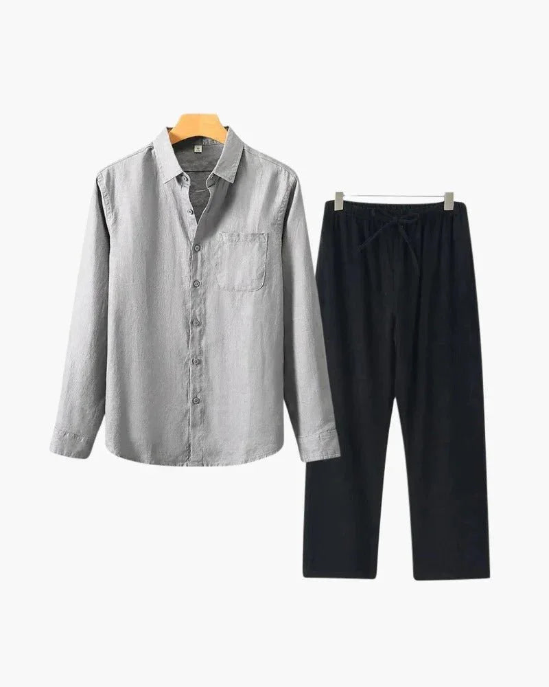 Men’s linen shirt and pants set in light gray and black on hangers, minimalist style