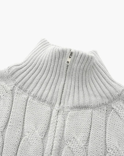 Light gray cable knit sweater with high ribbed zip collar on white background