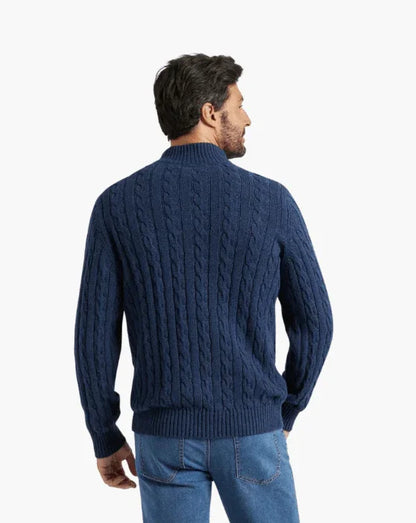 Man wearing a blue cable knit sweater and jeans, shown from the back