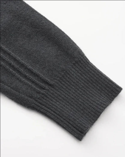 Dark gray knit sweater sleeve with ribbed cuff on white background