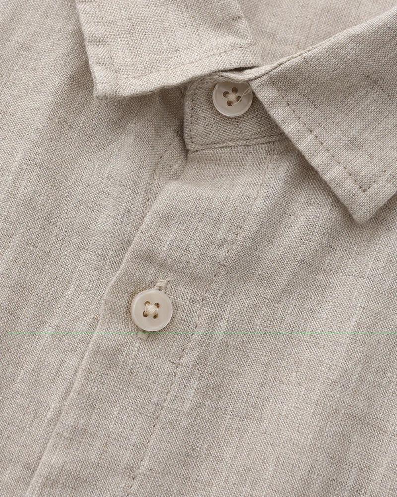 Close-up of beige linen shirt collar and buttons, natural lightweight fabric texture