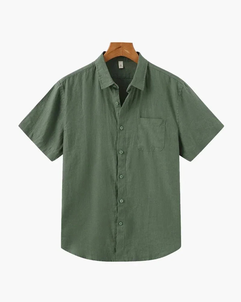 Green linen short sleeve button-up shirt with chest pocket on hanger