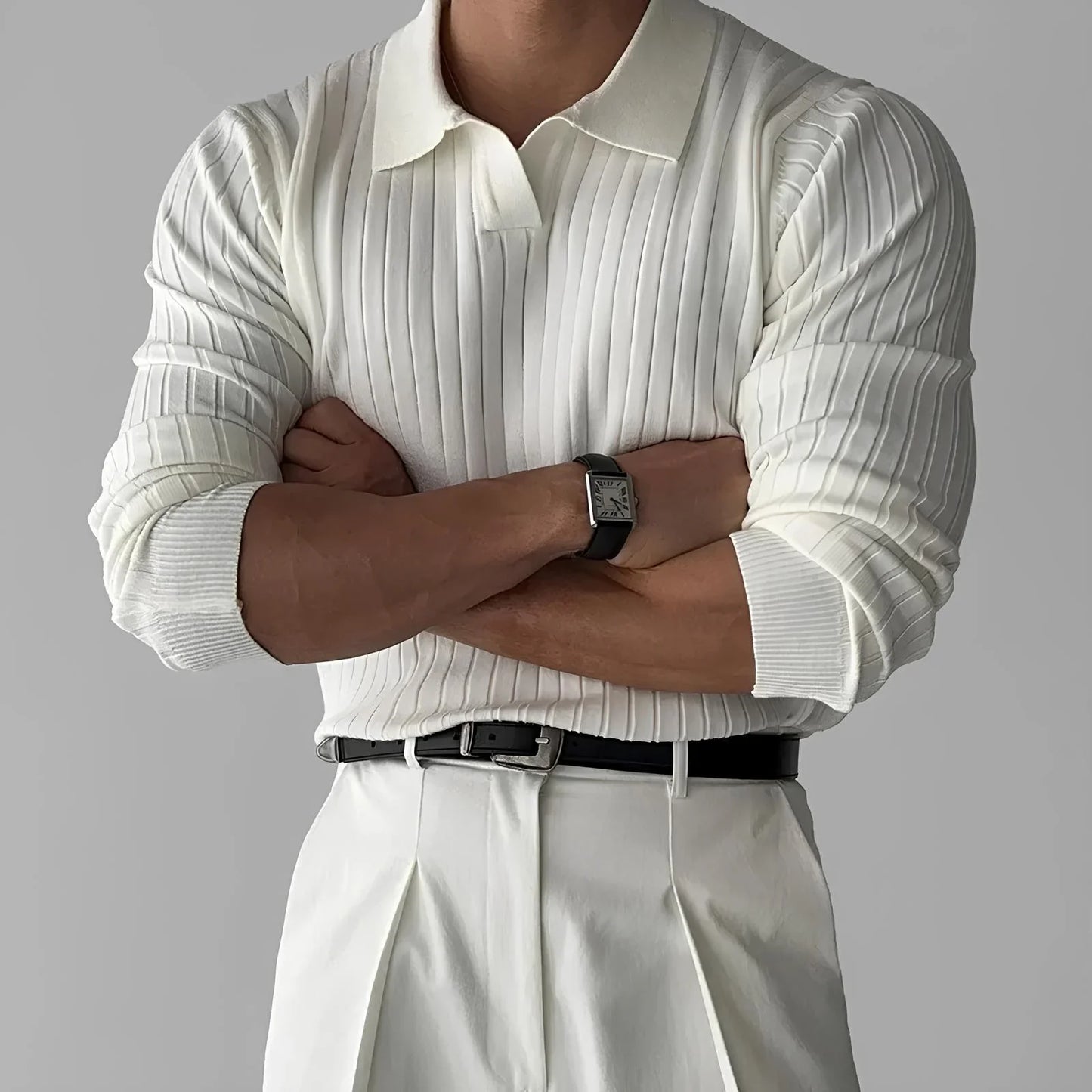 Man wearing white ribbed knit polo sweater, white pleated pants, and black belt
