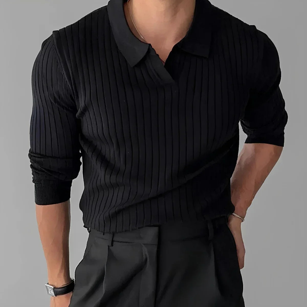 Man wearing black ribbed knit sweater with collar and black pants, minimalist style